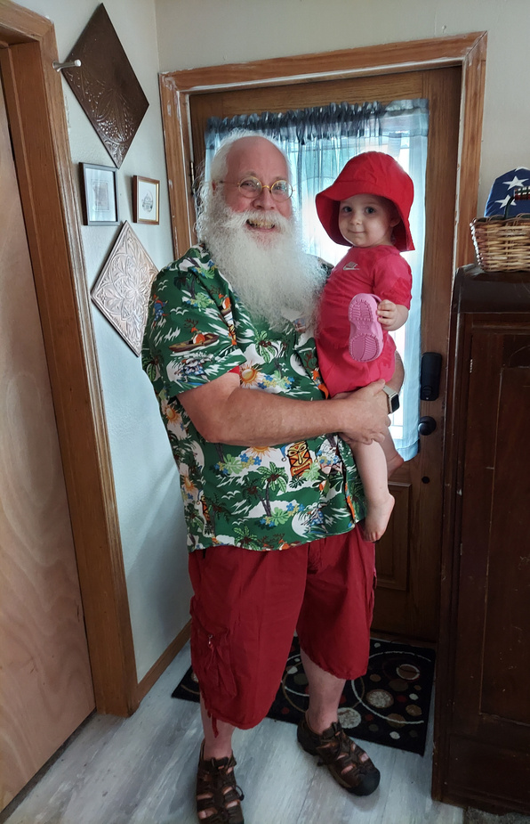 Santa, Papa Claus, with granddaughter, Birdie, as he heads out to Christmas in July event